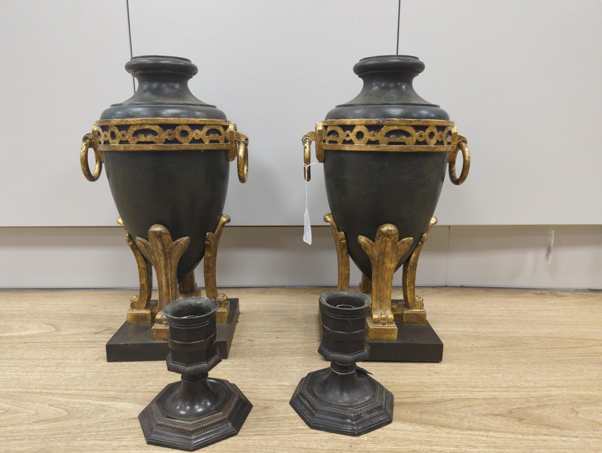 A pair of reproduction twin handled urns, together with a pair of reproduction cast metal candlesticks